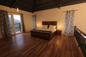 a bedroom with a bed and a wooden floor at Maktain Glance in Dehradun