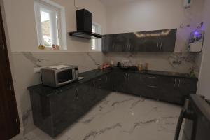 a kitchen with a counter with a tv on it at Maktain Glance in Dehradun