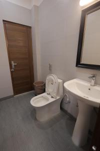 a bathroom with a toilet and a sink at Maktain Glance in Dehradun