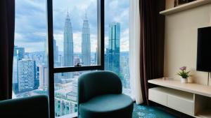 a room with a chair in front of a window at Imperial KLCC Residences in Kuala Lumpur