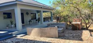 a porch of a house with two benches on it at Inyati Guest House in Marloth Park