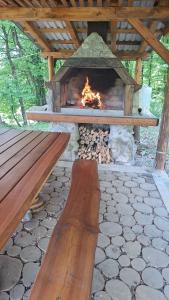 a fireplace with a wooden bench in front of it at Lake Crown in Ogulin