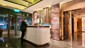 a man standing at a counter in a lobby at Imperial KLCC Residences in Kuala Lumpur +45 photos