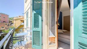 a room with a balcony with a blue shutter at Terre Marine Rooms in Riomaggiore