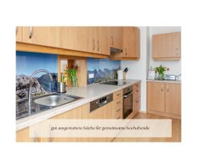 a kitchen with wooden cabinets and a sink at Ferienhaus Alpenblick, ganzes Ferienhaus, 5 Zi, 4 Bäder, gratis Parkplatz, Sonnenterrasse in Heiligenblut