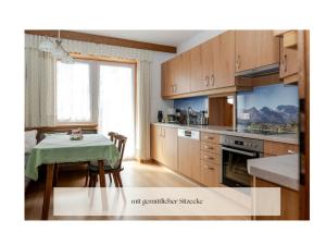 a kitchen with a table and a dining room at Ferienhaus Alpenblick, ganzes Ferienhaus, 5 Zi, 4 Bäder, gratis Parkplatz, Sonnenterrasse in Heiligenblut