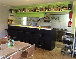 a kitchen with two tables and a bar with stools at Ferienpark Tannenbruchsee in Neustadt am Rübenberge