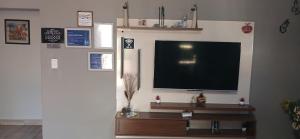 a living room with a flat screen tv on a wall at Inyati Guest House in Marloth Park