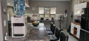 a kitchen with a table and chairs in a kitchen at Inyati Guest House in Marloth Park