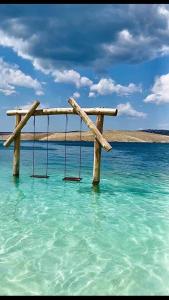a swing in the water in the ocean at Apartman Gema in Skrad