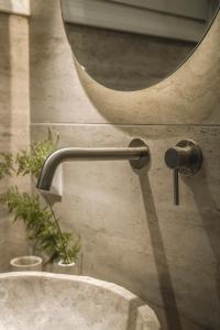 a bathroom sink with a faucet and a mirror at Akari - Luxury Apartment in Preveza