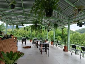 an outdoor patio with tables and chairs and plants at Half Way Villa in Luang Prabang +5 photos