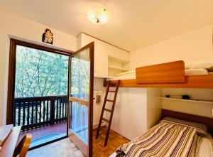 a bedroom with a bunk bed and a balcony at Dolomites Soundscape - Birds River Snow Ski Bus Bike Hike in Alleghe