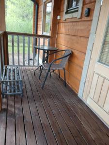 a table and chair on the porch of a cabin at Villa Polly, Jaala, Luxury cottage with private sauna in Kouvola