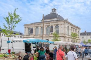 a group of people walking around a market in front of a building at La Casetta refuge méditerranéen et balnéo classé 3 étoiles in Wizernes