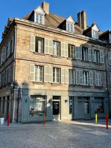 an old building on a street with a store at La Villa Louana 4 Appartement neuf et moderne tout confort in Aubusson