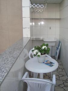 una pequeña mesa blanca con una maceta en ella en Quarto Masculino Compartilhado em Santa Teresa, en Río de Janeiro