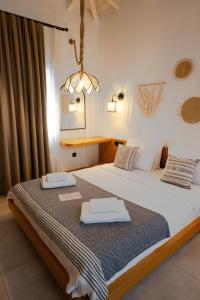 a bedroom with a large bed with towels on it at Kotraba Alacati Hotel in Alaçatı +90 photos