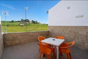 a white table and chairs with a view of a field at Piso La Buganvilla in Bailén