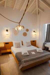 a bedroom with a large bed with a chandelier at Kotraba Alacati Hotel in Alaçatı