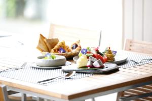 a table with plates of food and a basket of bread at Maraleina Sports Resort in Nathon Bay +50 photos