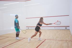 a man and a woman playing a game of tennis at Maraleina Sports Resort in Nathon Bay