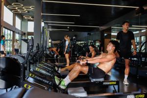 a man sitting on a bench in a gym at Maraleina Sports Resort in Nathon Bay