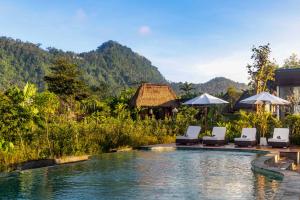 a pool at a resort with chairs and umbrellas at Anandinii Resort Sidemen by AGATA in Sidemen +42 photos