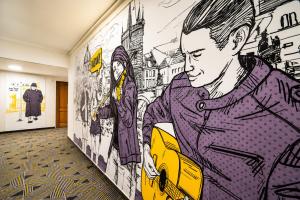 a hallway with a wall mural of a man at Hotel Uno Prague in Prague