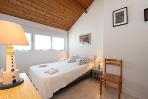 a bedroom with a bed and a table and a chair at La Proue , duplex face mer in Arzon