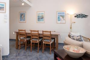 a living room with a dining room table and a couch at La Proue , duplex face mer in Arzon +16 photos