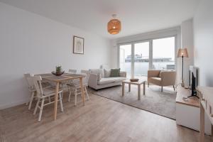 a living room with a table and chairs and a television at La belle étoile - 4 pers - balcon in Vannes