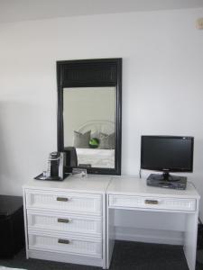 a white dresser with a television and a mirror at Sole East Beach in Montauk