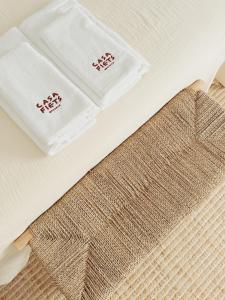 a bed with two white towels on top of it at Hotel Casa Fiets in Alaior