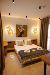 a bedroom with a bed with two towels on it at Kotraba Alacati Hotel in Alaçatı