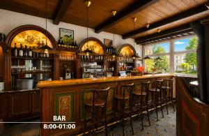 a bar with wooden bar stools in a room at Hotel Uno Prague in Prague