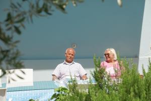 a man and a woman sitting at a table at Domizil Lina Art in Güzelçamlı