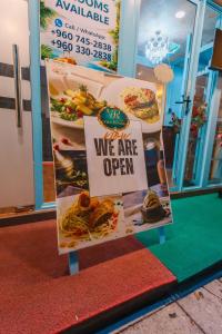a sign that says we are open in front of a restaurant at Vilu Central in Hulhumale