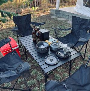 a picnic table with two chairs and bottles of beer at CAELO | Peaceful Mountain View Rive in Pililla +6 photos