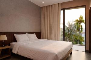 a bedroom with a large bed and a large window at HOA GIO Boutique stay in Hue