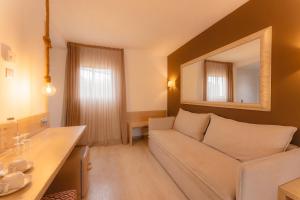 a living room with a couch and a mirror at Garden Saladina - Adults Only in Playa de Muro
