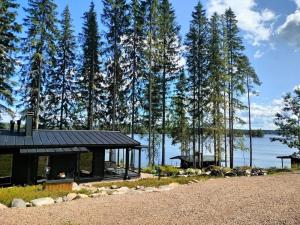 a house on the shore of a lake with trees at Villa Vaalanto in Pomarkku