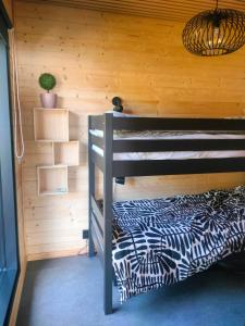 a bedroom with a bunk bed in a wooden wall at Villa Vaalanto in Pomarkku