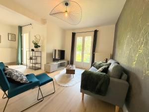 a living room with a couch and a tv at Le Cocon de Vabre, maison calme in Onet le Château