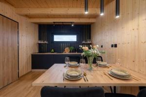 a wooden table with plates and glasses on top of it at Comfortable holiday home, pool, sauna, jacuzzi in Kopań