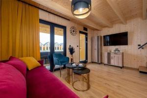 a living room with a pink couch and a table at Comfortable holiday home, pool, sauna, jacuzzi in Kopań