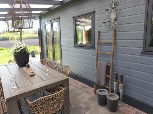 a wooden table and chairs on a patio at Vechtdal Chalet de Wilg in Rheezerveen +21 photos