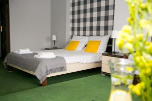 a bedroom with a bed with two yellow pillows at Labirynt in Łomża