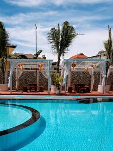 a pool at a resort with trees and palm trees at The Holiday Resort Pattaya in Pattaya +140 photos