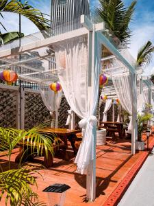 a white pergola on a patio with a table at The Holiday Resort Pattaya in Pattaya